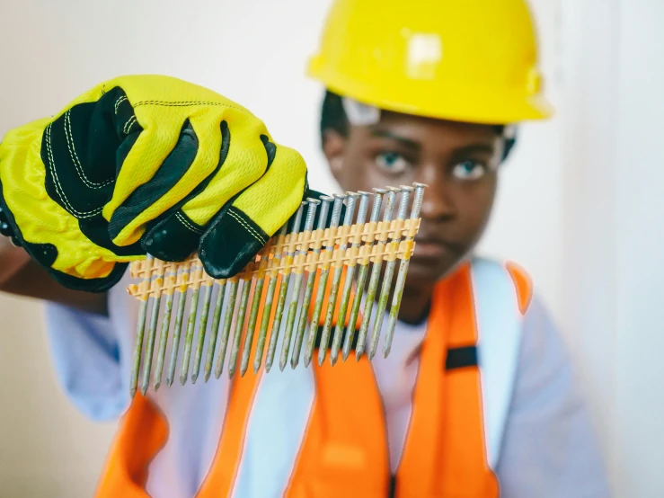 a construction worker with work gloves and safety jackets on holds a comb