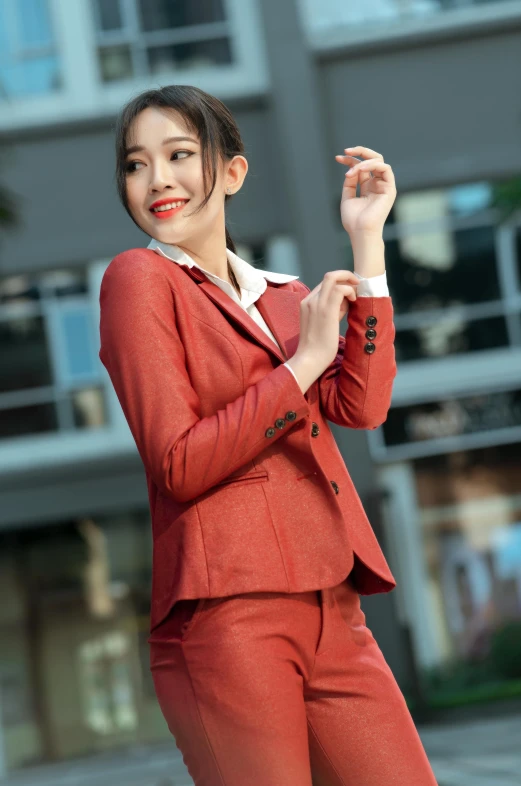 an asian woman in a red suit poses for a po