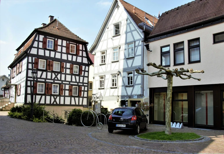 cars and bicycles parked next to some older buildings