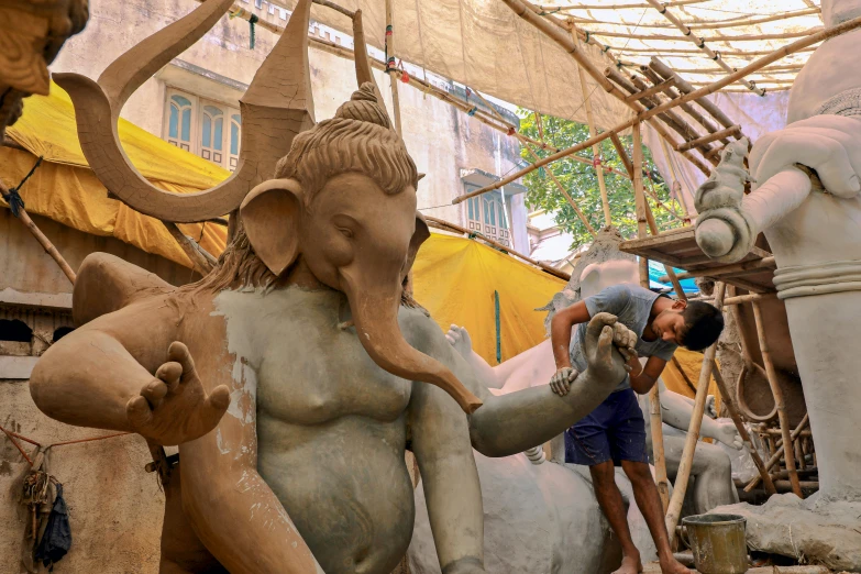 an elephant statue being cleaned by a man