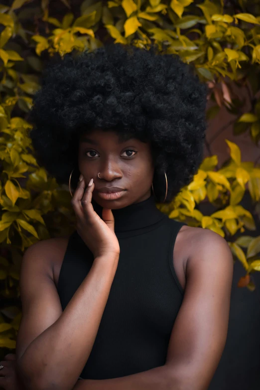 a black female poses for the camera with an afro