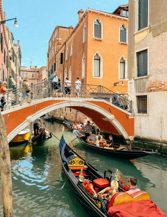 a group of boats floating under a bridge