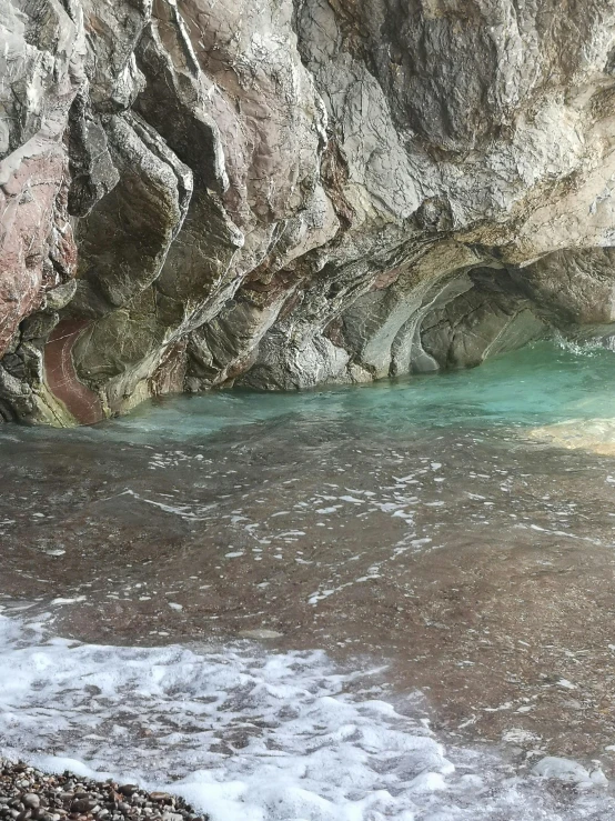 two people at the beach near an icy water creek