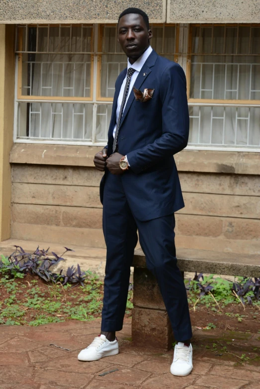 man in dark colored suit posing for picture