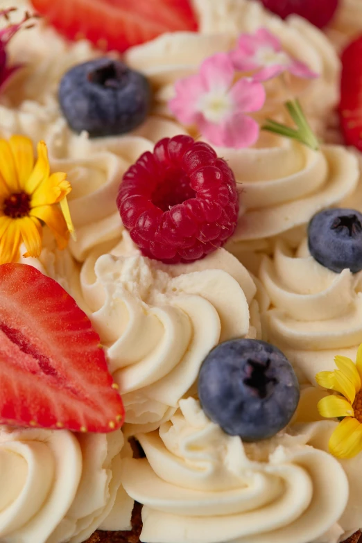 a cake decorated with icing, flowers, and berries