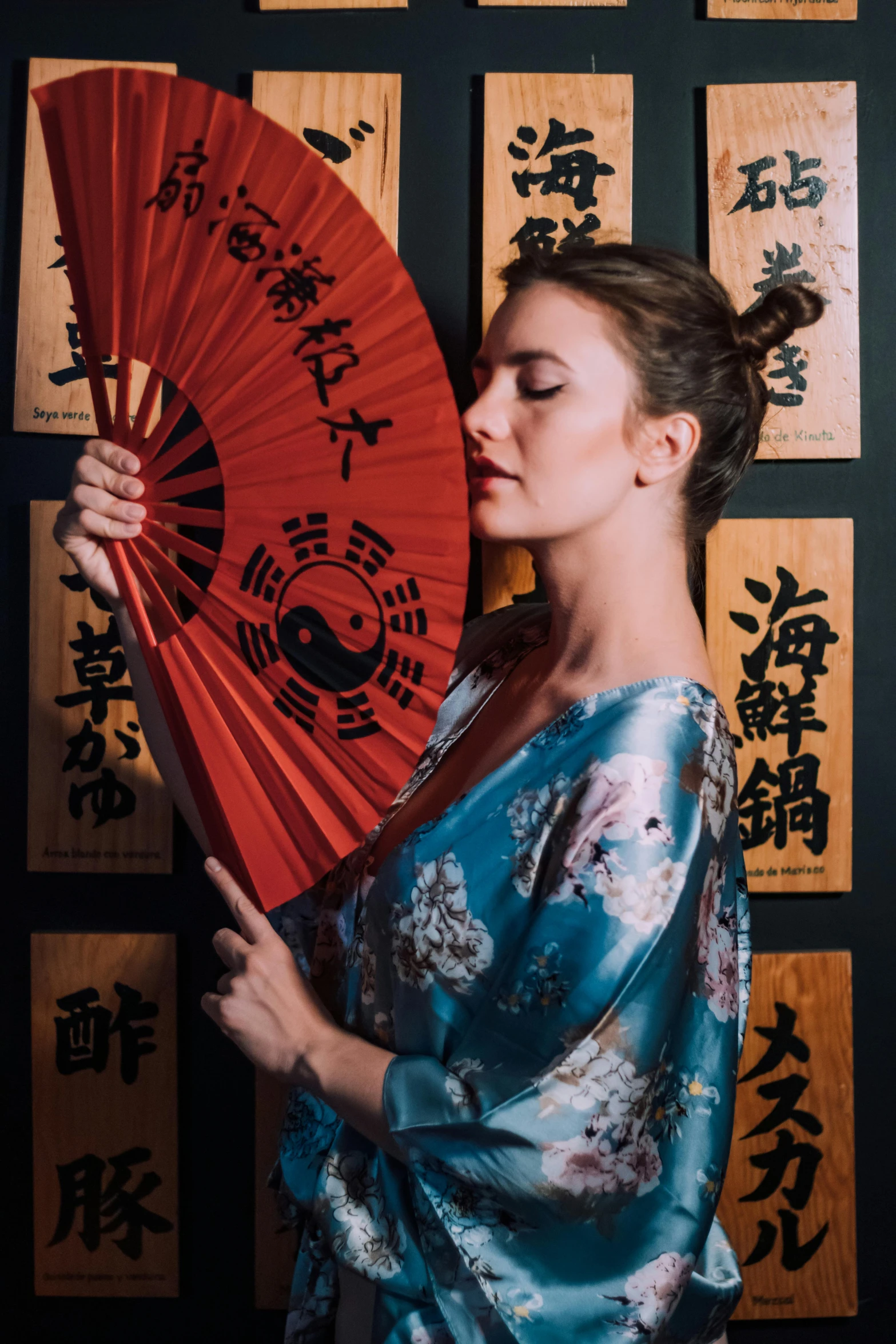 a woman with a red umbrella in front of a wall