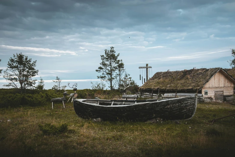 an old wooden boat sits in front of the small hut