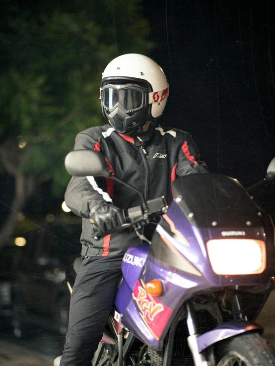 a man riding on the back of a purple motorcycle