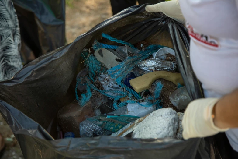 a person holding a bag full of garbage