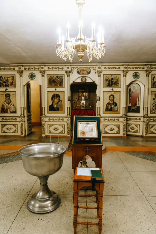 an ornate room with paintings and a vase next to a chair