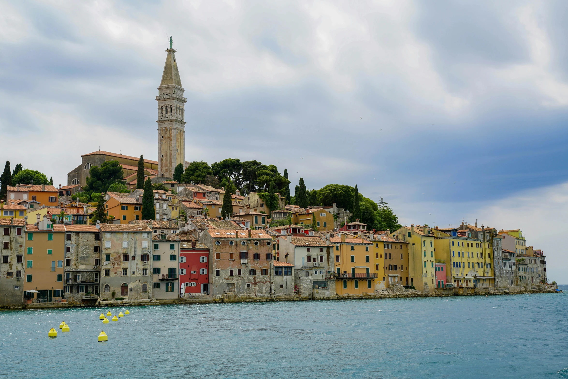 a city with a very tall steeple near the water