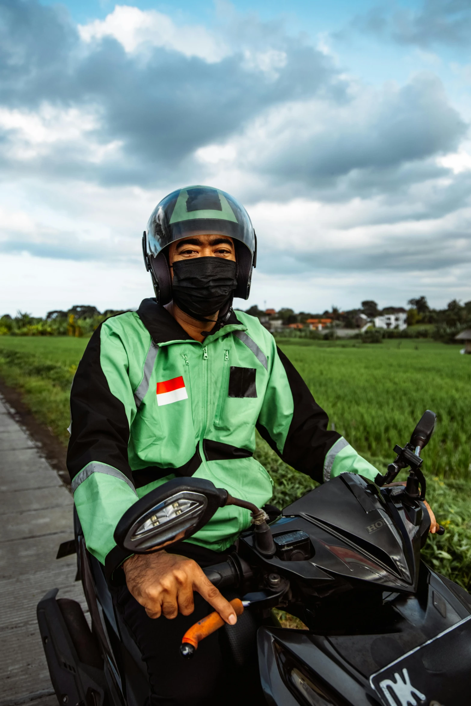 a person riding a motorcycle down a road with grass