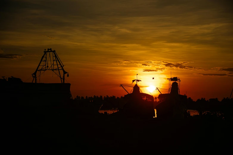 the sun setting over boats in the water