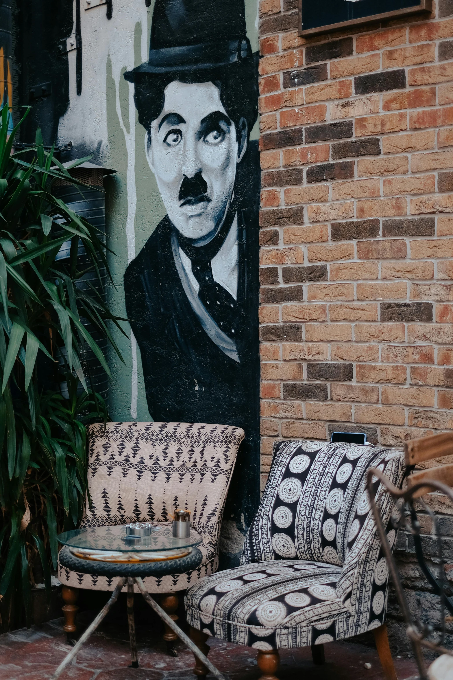 two chairs and a hat are next to a painted mural