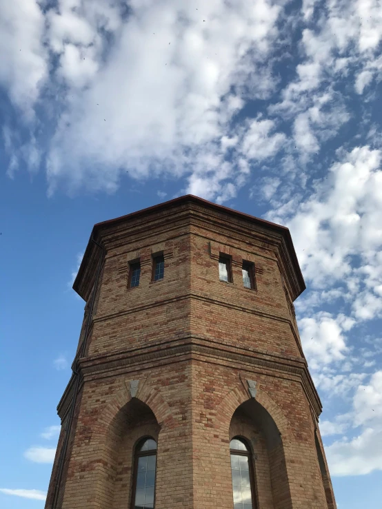 a tall brick building with a sky background