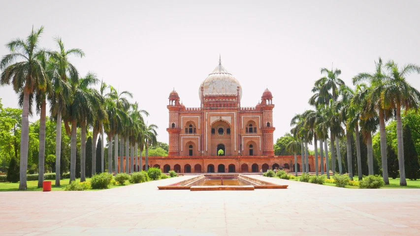 a large building in a park that has palm trees around it