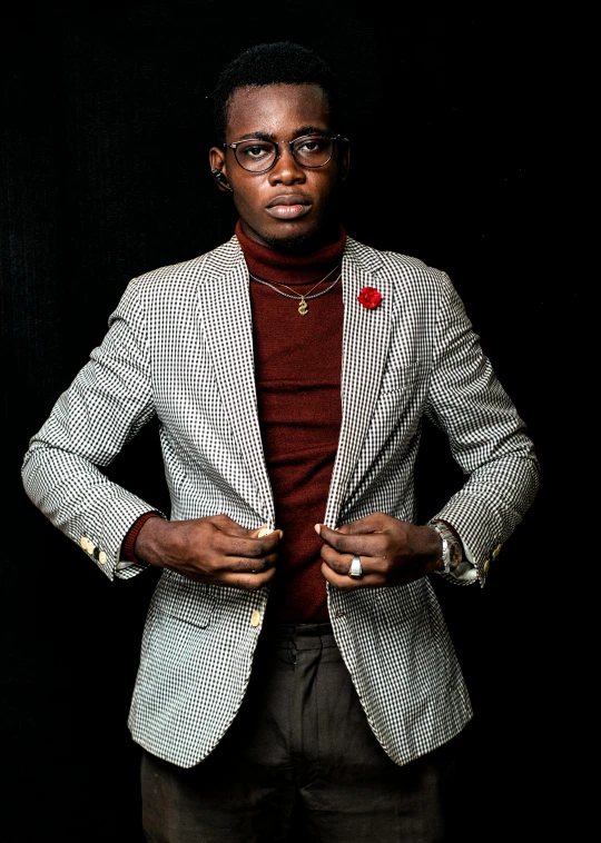 a black man standing in a suit and red sweater