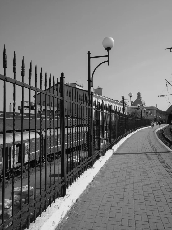 a rail yard fence along side a city street