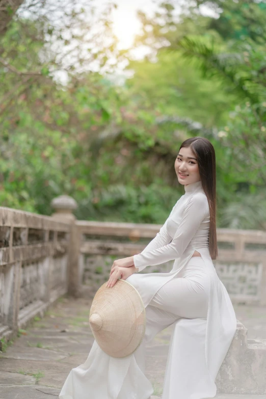 a woman sitting on steps near some water with a straw hat