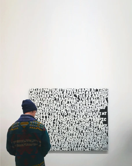 a man standing in front of a black and white painting