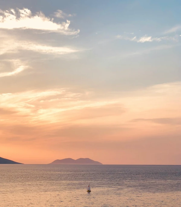 people are out on the water at sunset while one rides a surfboard