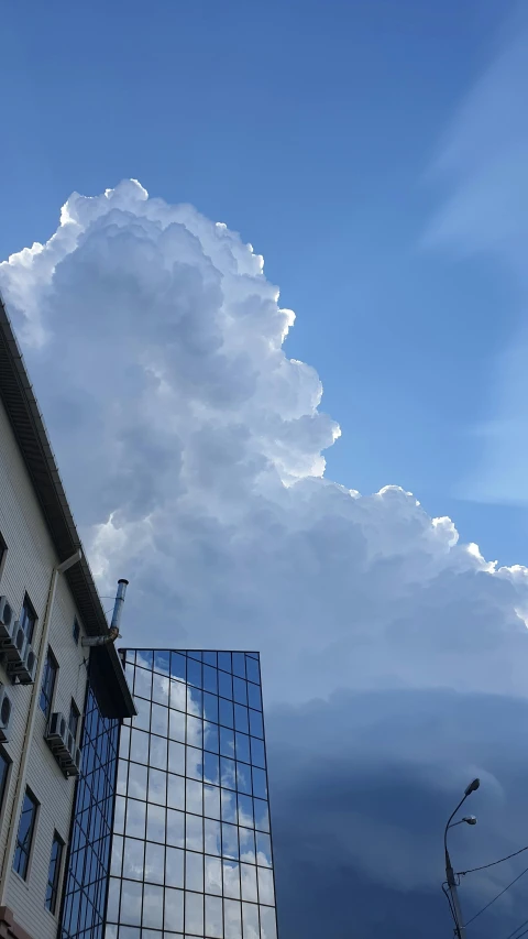 a large cloud is in the blue sky behind buildings