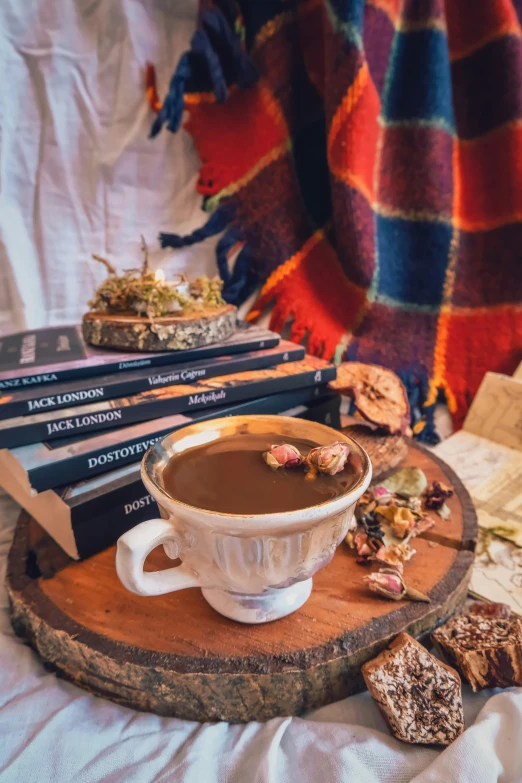 cup filled with  chocolate sitting on top of a wooden serving platter