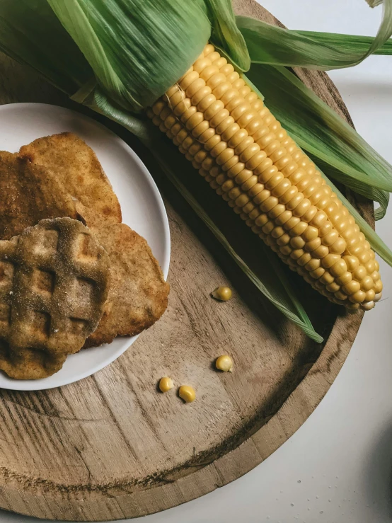 a plate of fried pastries with corn on the cob
