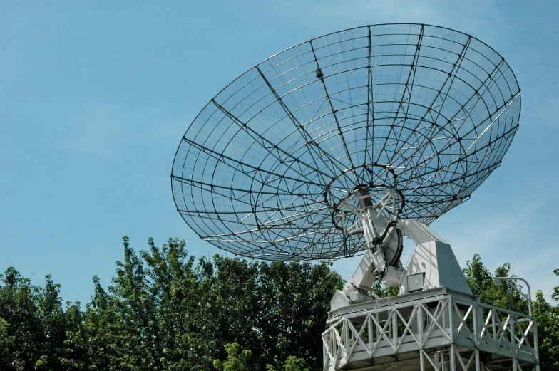 a satellite dish sits in front of trees