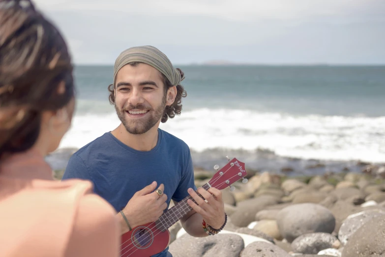 a man plays the ukulele next to a woman