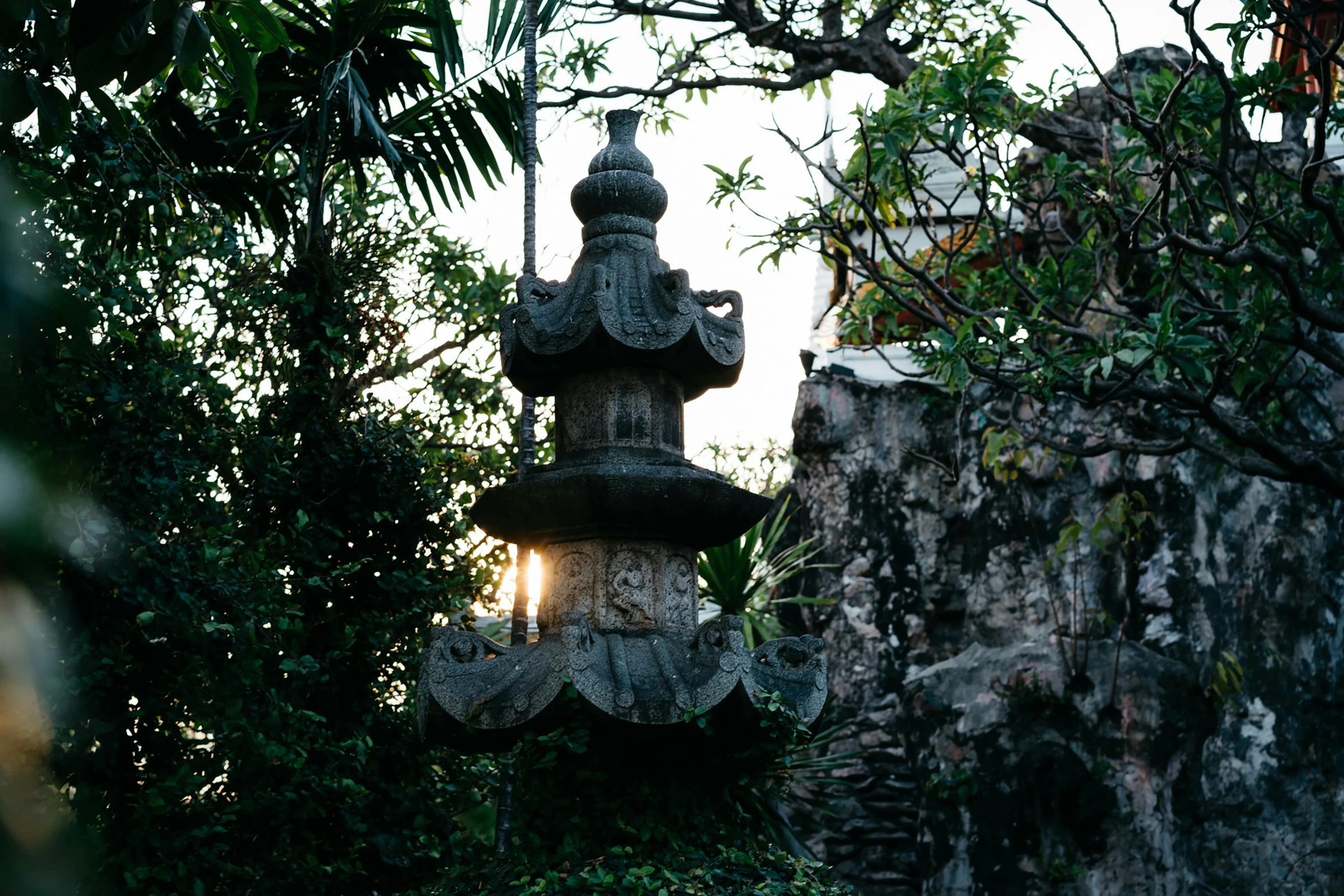 an antique lamp surrounded by trees and plants