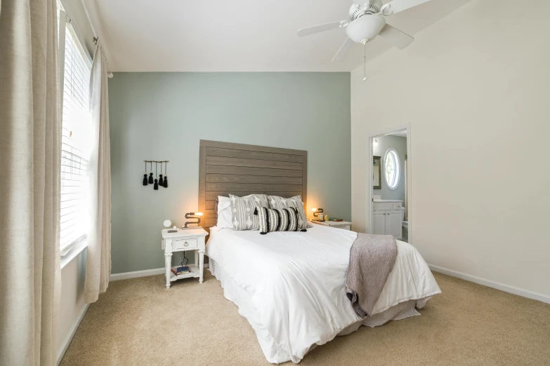 a large bed in a white bedroom with neutral decor