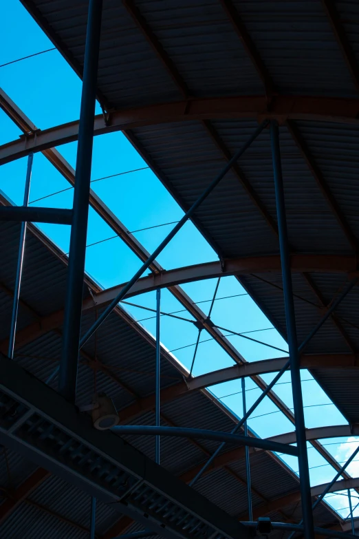 looking through the inside of an open structure at a plane flying overhead