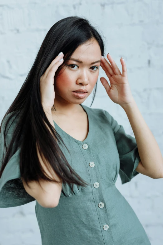 a beautiful young woman holding her head with one hand