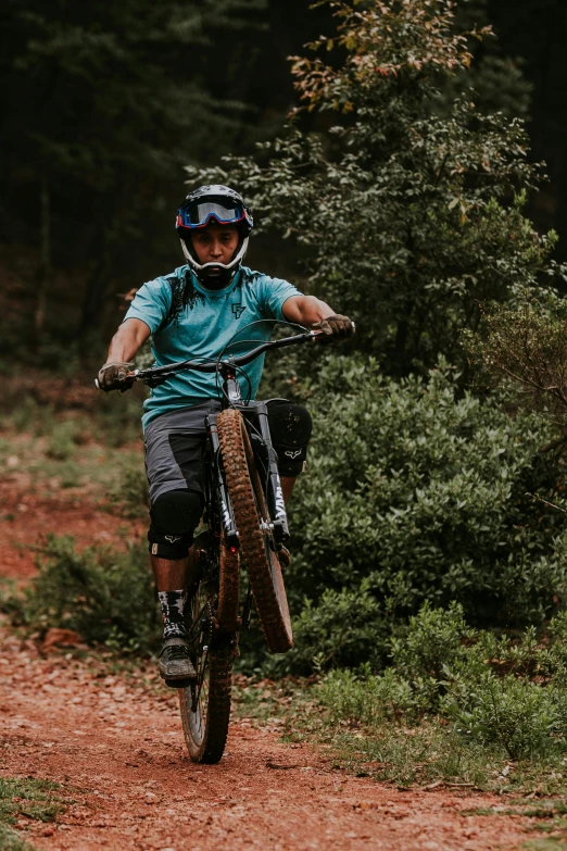 a man with a blue shirt and helmet is riding a bike