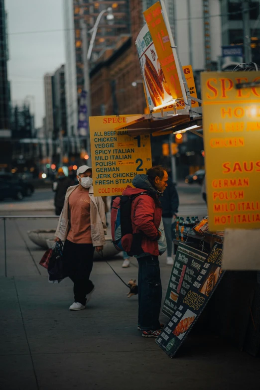 people walk down the sidewalk at night with signs, posters and lights