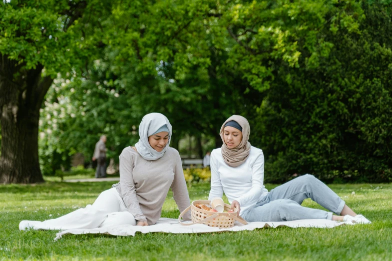 two women are sitting on the ground next to each other