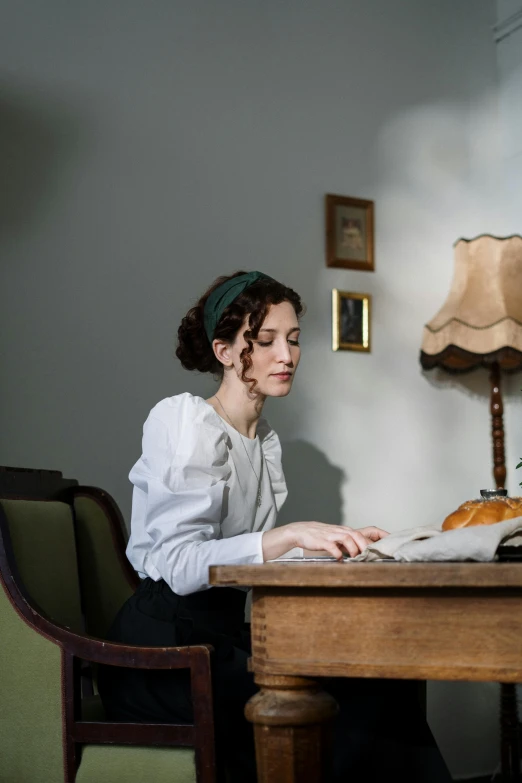 an old lady sitting at a desk with a laptop