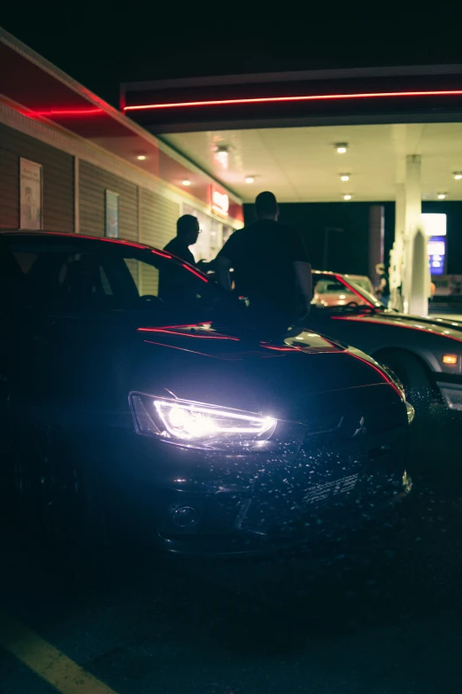 two cars are parked in front of a gas station