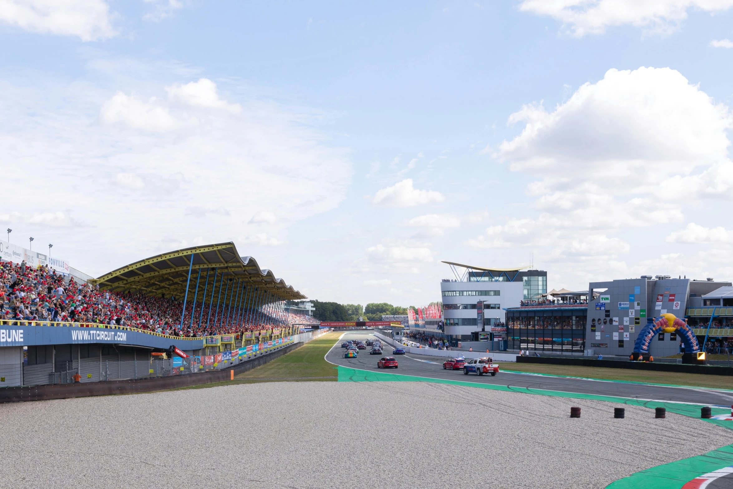 a group of spectators watching cars race around a track