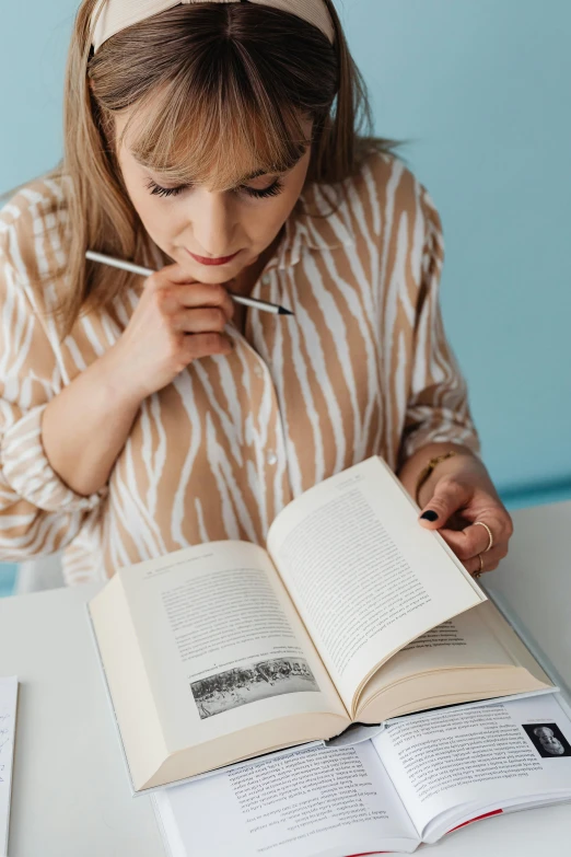 a woman reading a book while leaning over it