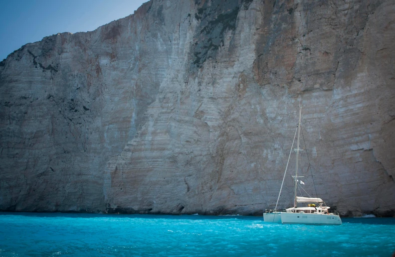 a boat is on the water by the big mountain