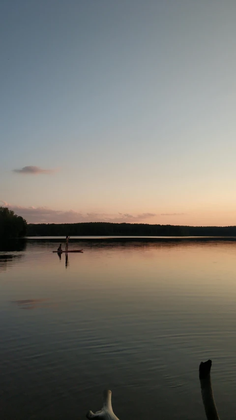 a person on a paddle board in calm waters