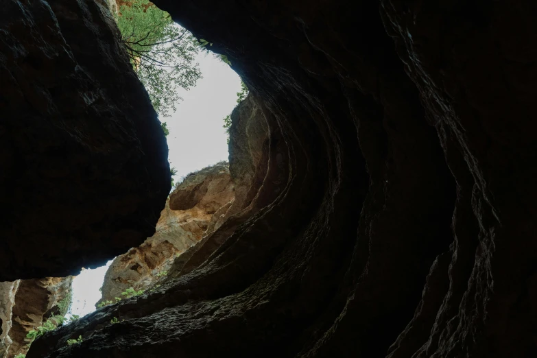 a view of some dark rocks with a sky background