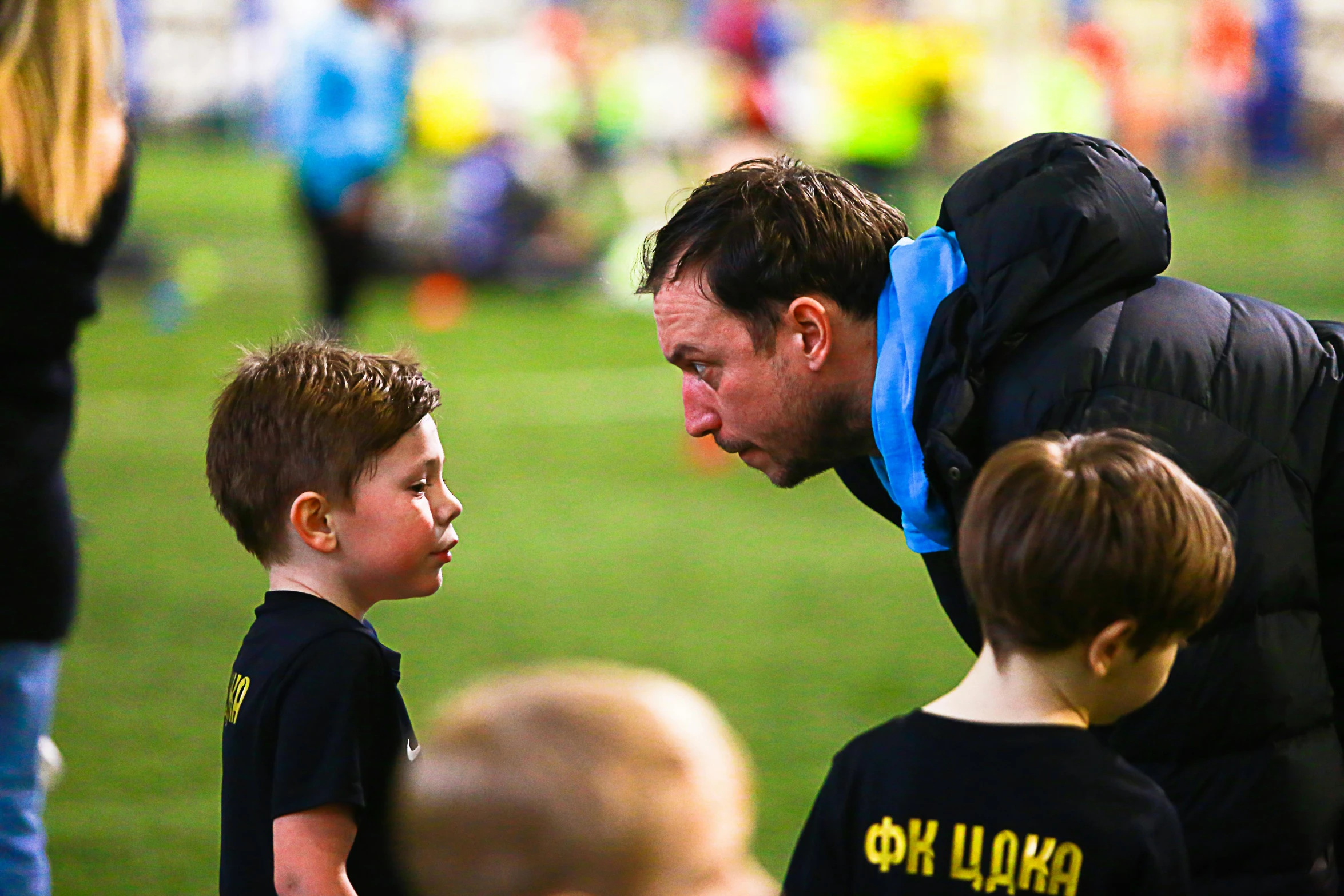 a man is talking to some children and an older woman