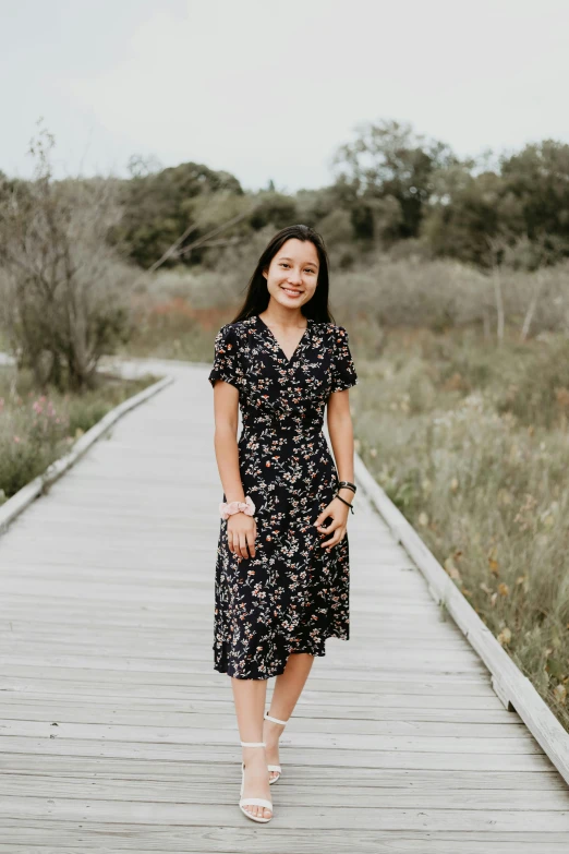 a woman standing on a long wooden pier