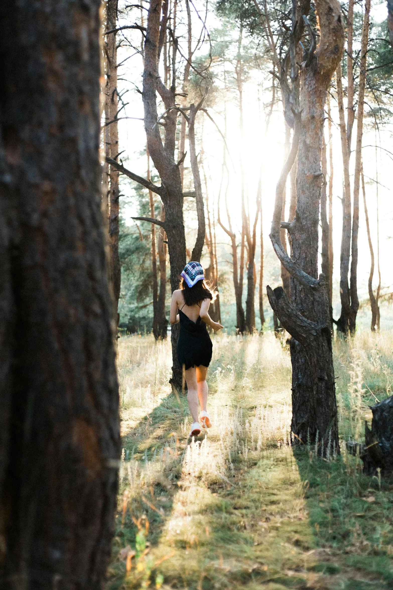 woman walking through the woods on a sunny day