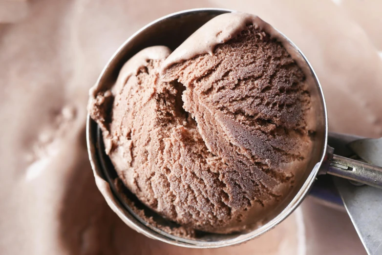 ice cream in a bowl with one spoon and a small scoop