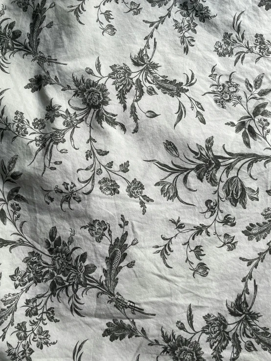 close up po of a white cloth with floral design