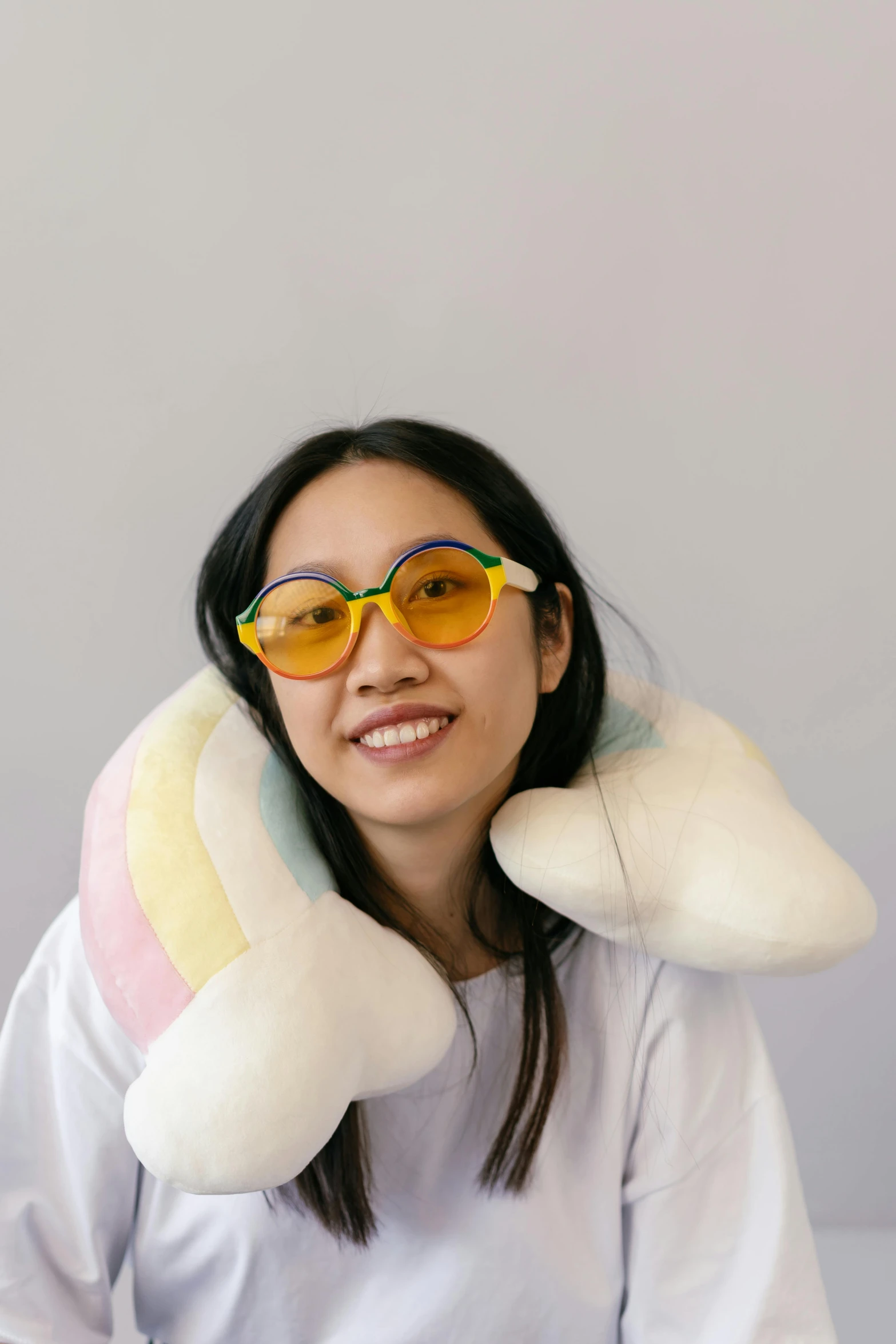 a young woman wearing large sunglasses and holding onto a stuffed animal